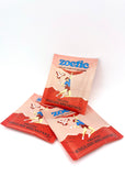 Zoetic Organic English Breakfast tea packaging depicts a person rock-climbing with bird of prey holding a tea bag next to them. The illustration is on a pink background with red rocks/mountains.