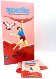 Zoetic Organic English Breakfast tea packaging depicts a person rock-climbing with bird of prey holding a tea bag next to them. The illustration is on a pink background with red rocks/mountains.